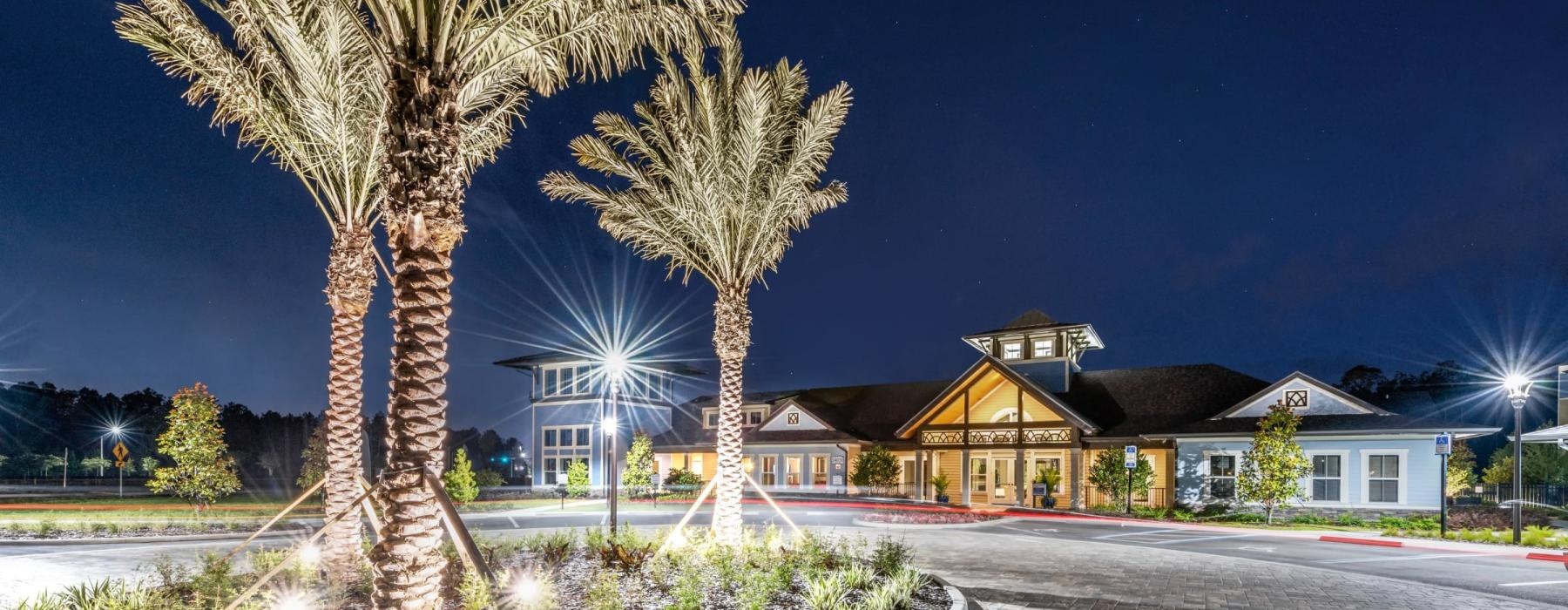 a building with palm trees and a fountain in front of it